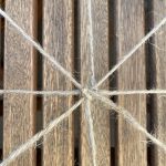 Auf dem Grundnetz von vier gekreuzten Fäden wird reihum gewebt.