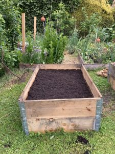 Die Hochbeete werden mit Kompost aufgefüllt.