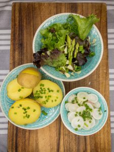 Frühlingsplatte mit Pflücksalat und Radieschen Salat.