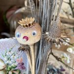 Trockengesteck Mohnkapsel Gesicht.